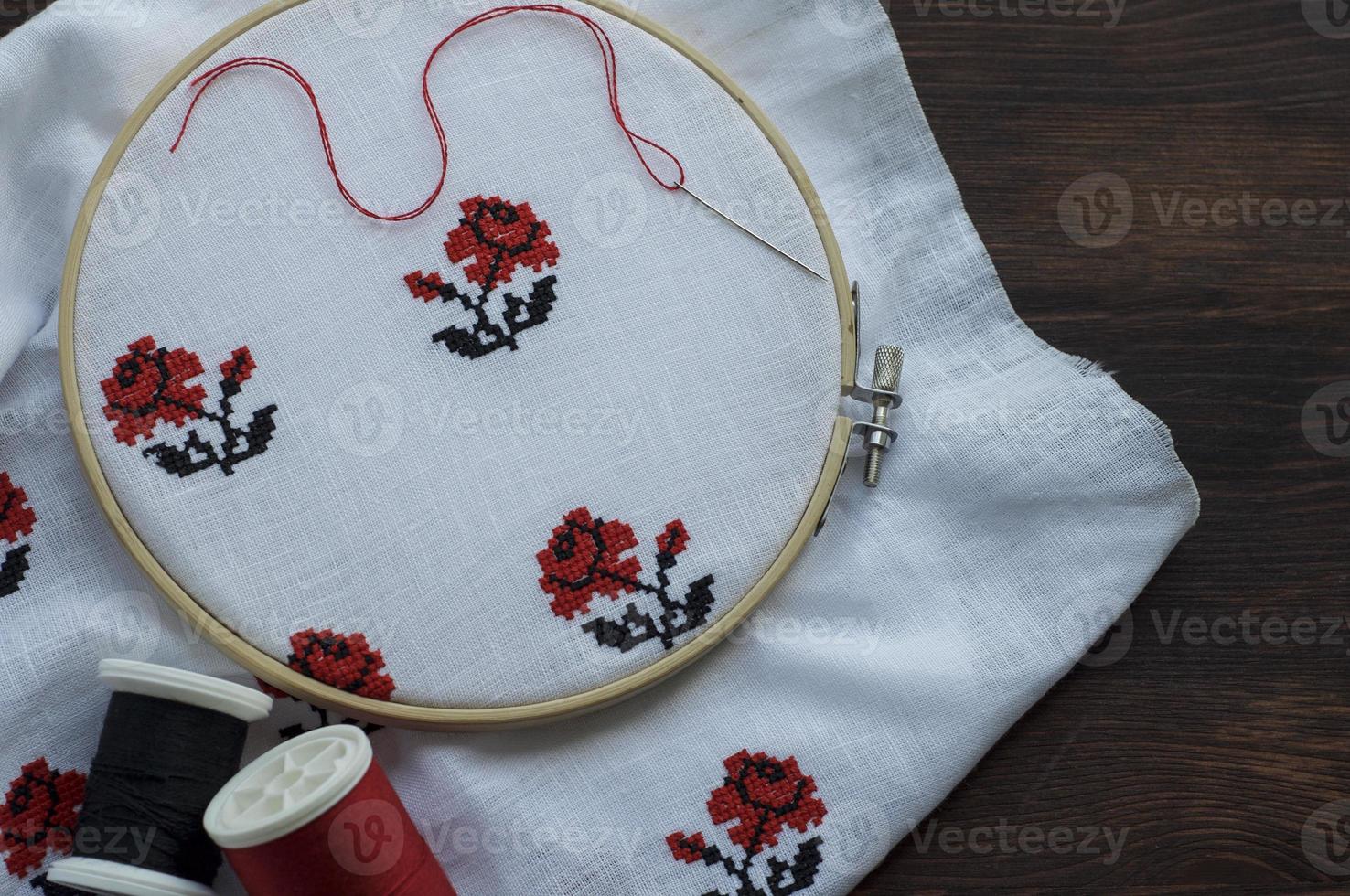 White cloth with hand-embroidered with a cross in the hoop photo