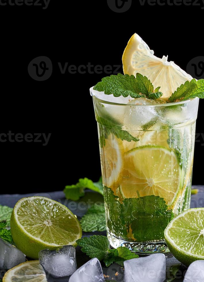 summer refreshing drink lemonade with lemons, mint leaves, ice cubes and lime in a glass photo
