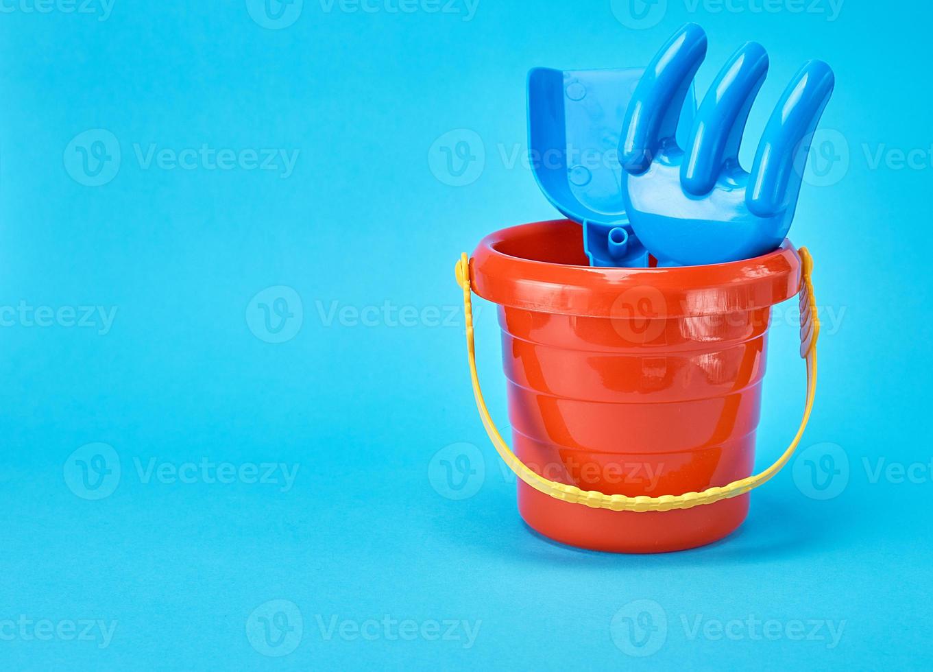 baby plastic red bucket and shovel with a rake photo