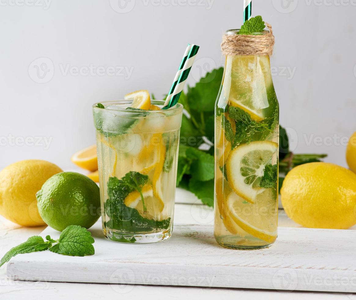 summer refreshing drink lemonade with lemons, mint leaves, lime in a glass photo