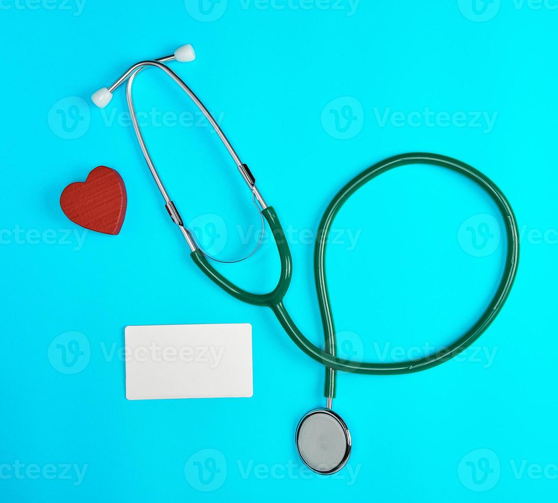 medical stethoscope and empty paper business cards on a blue background photo