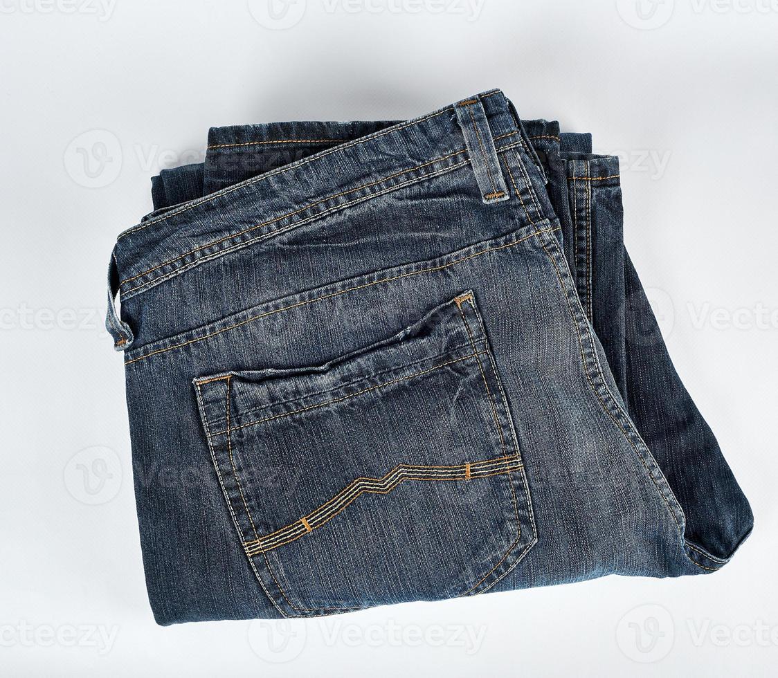 folded blue men's jeans on a white background photo