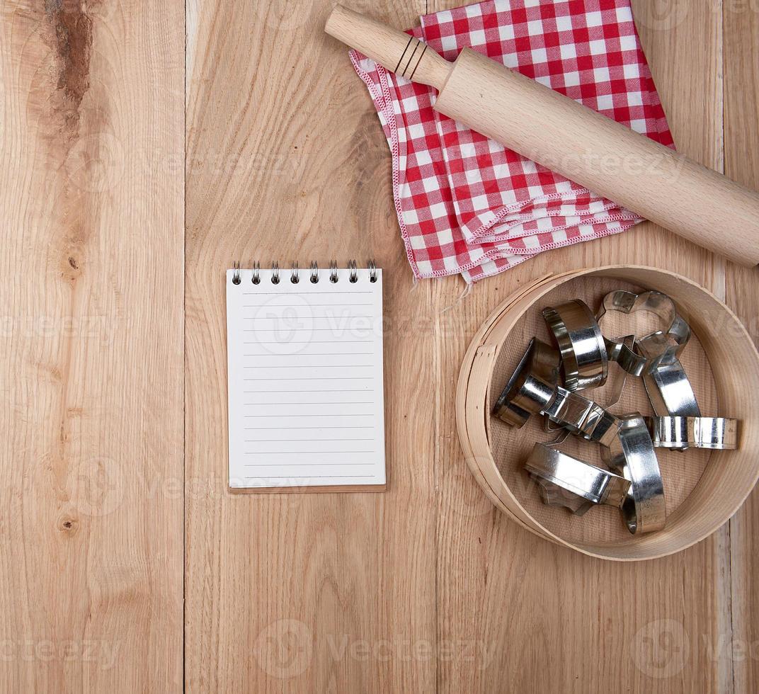 cuaderno abierto en una celda, tamiz redondo de madera foto