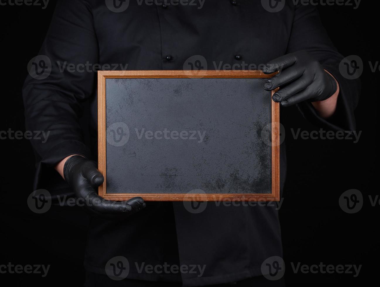 chef in black uniform  holds an empty wooden frame photo