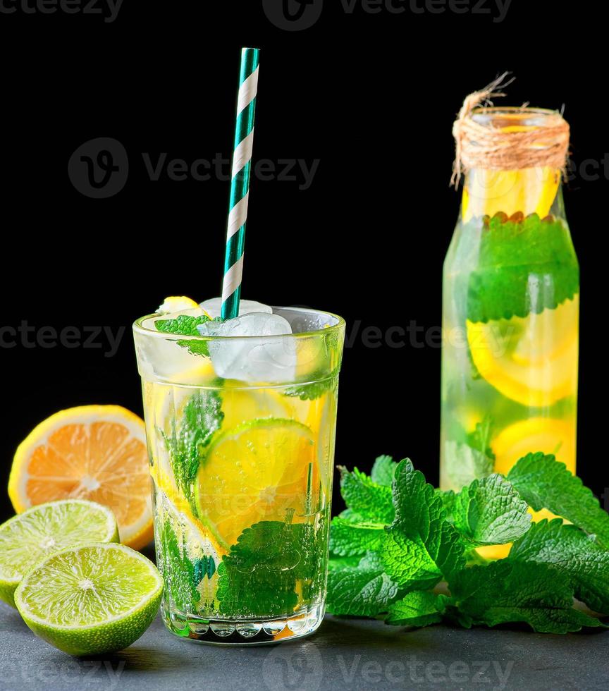 refreshing drink lemonade with lemons, mint leaves, ice cubes and lime in a glass photo