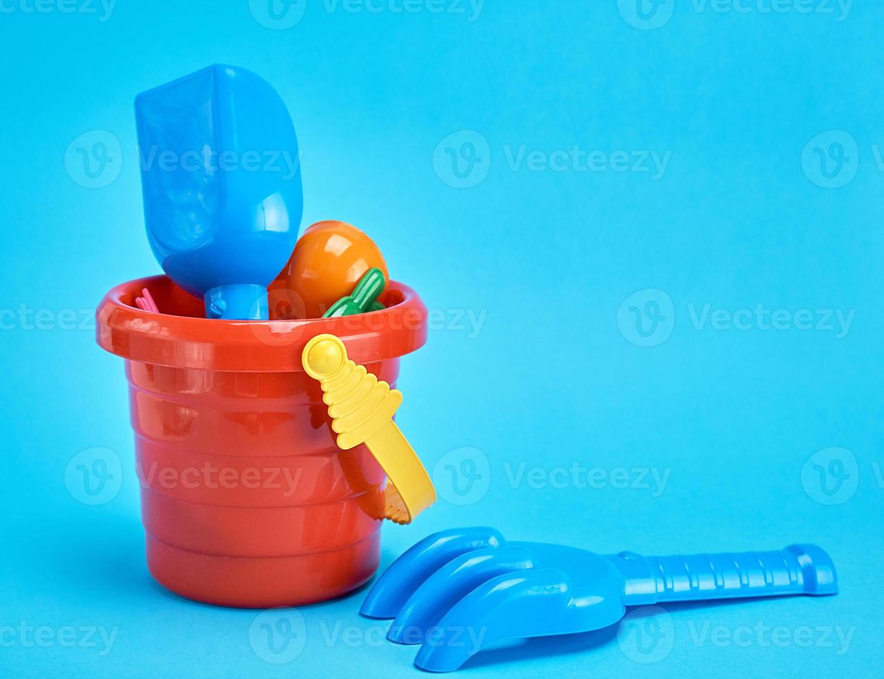 baby plastic red bucket and shovel with a rake photo