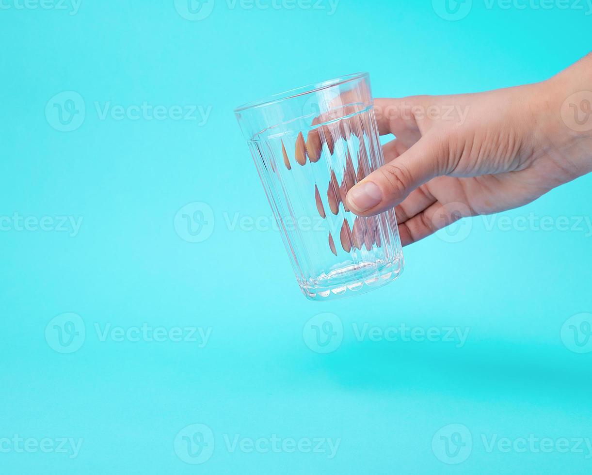 woman's hand holding an empty transparent glass photo