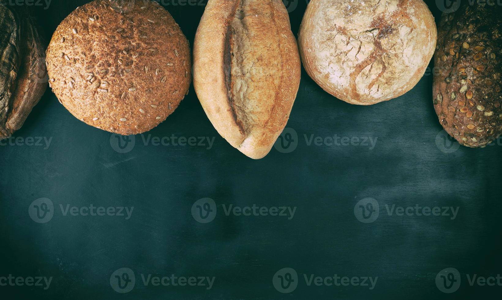 baked various loaves of bread on a black background photo