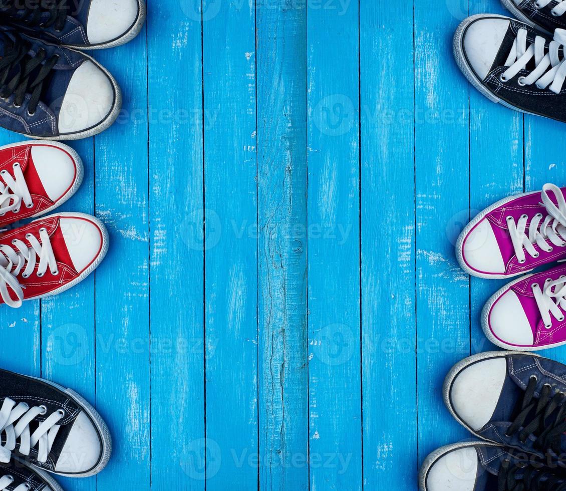 Youth colored sneakers on a blue background of the wooden planks photo