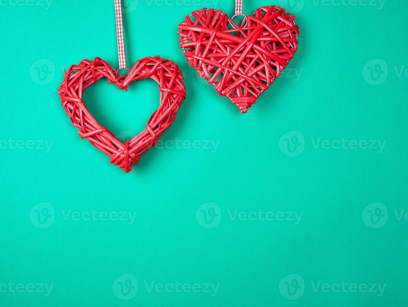 two wicker red hearts on a green background photo