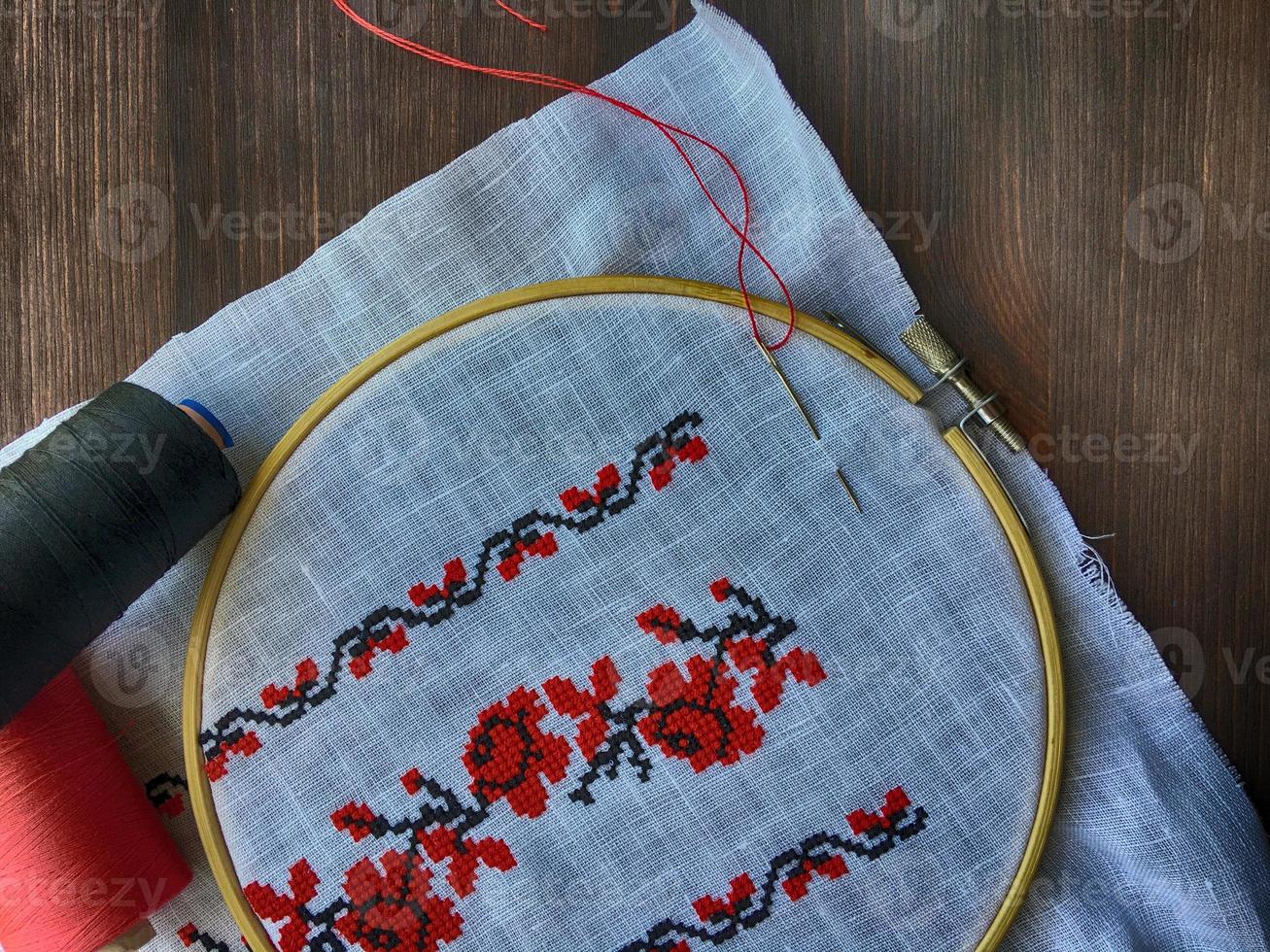 fabric in the wooden embroidery hoop with traditional folk embroidery Ukraine, top view photo