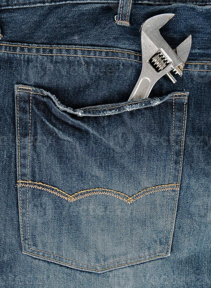 metal adjustable wrench in blue jeans back pocket photo