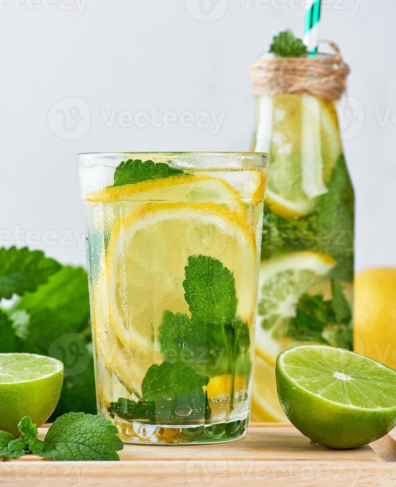 summer refreshing drink lemonade with lemons, mint leaves, lime in a glass photo