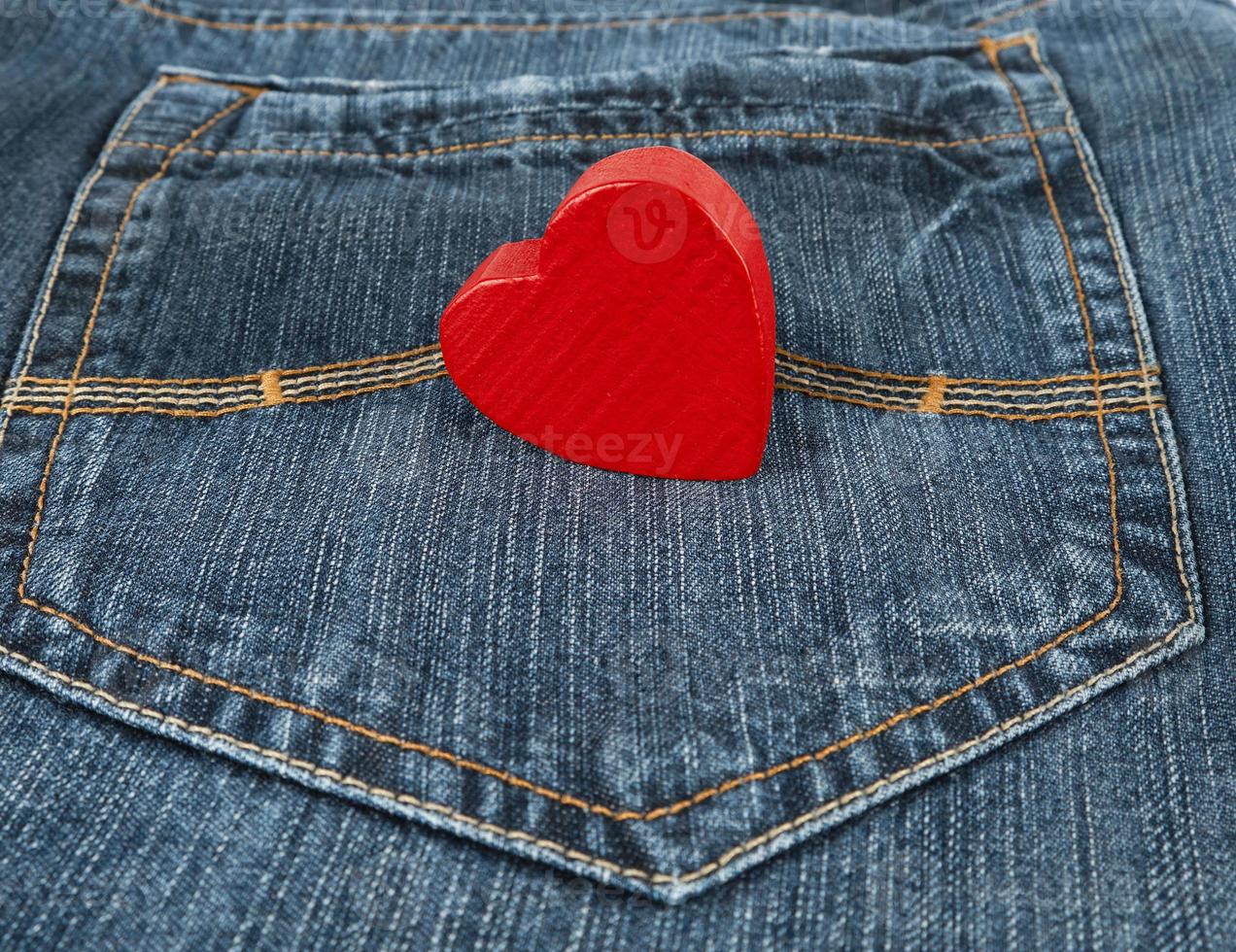 small red heart lies in the back pocket of blue jeans photo