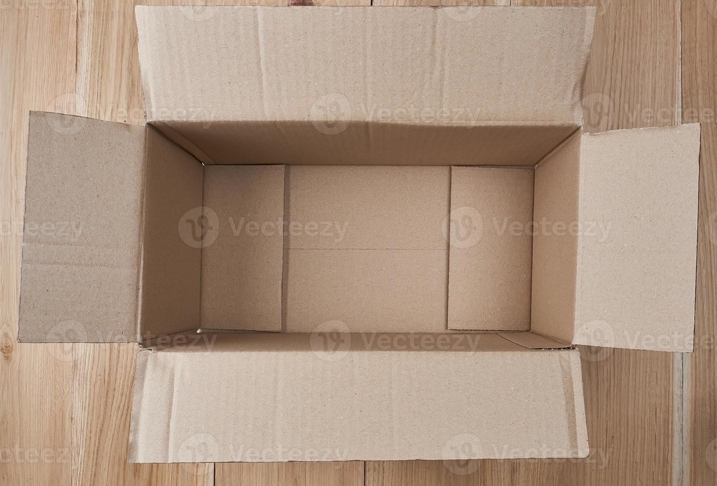 open empty rectangular box of brown cardboard on a wooden background photo