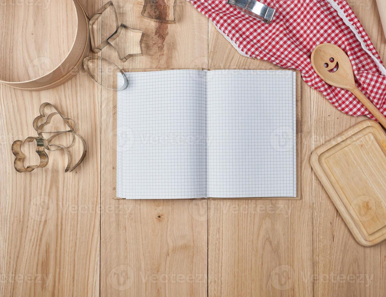 cuaderno abierto en blanco en línea y accesorios de cocina de madera foto