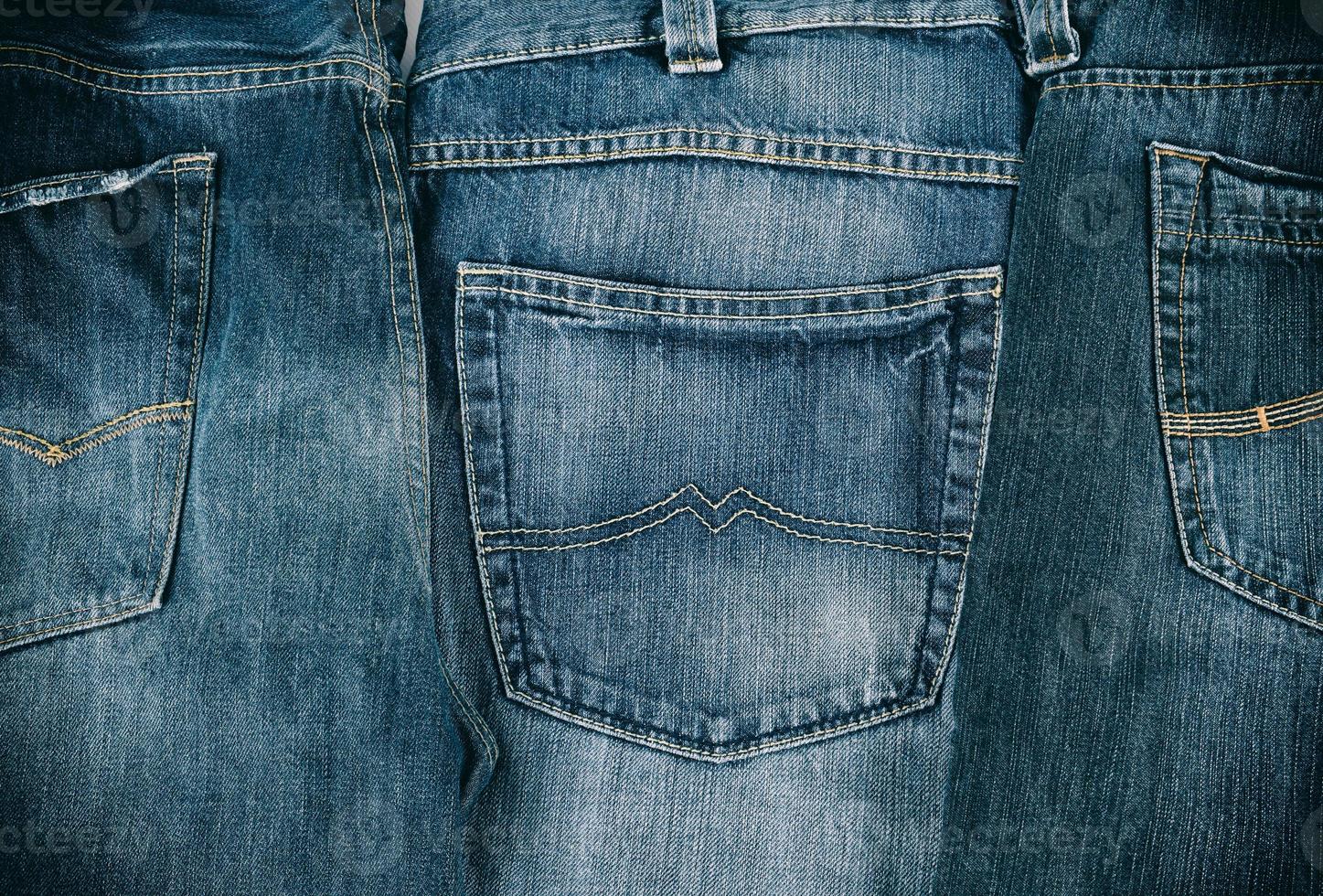 several blue classic jeans folded in a row photo