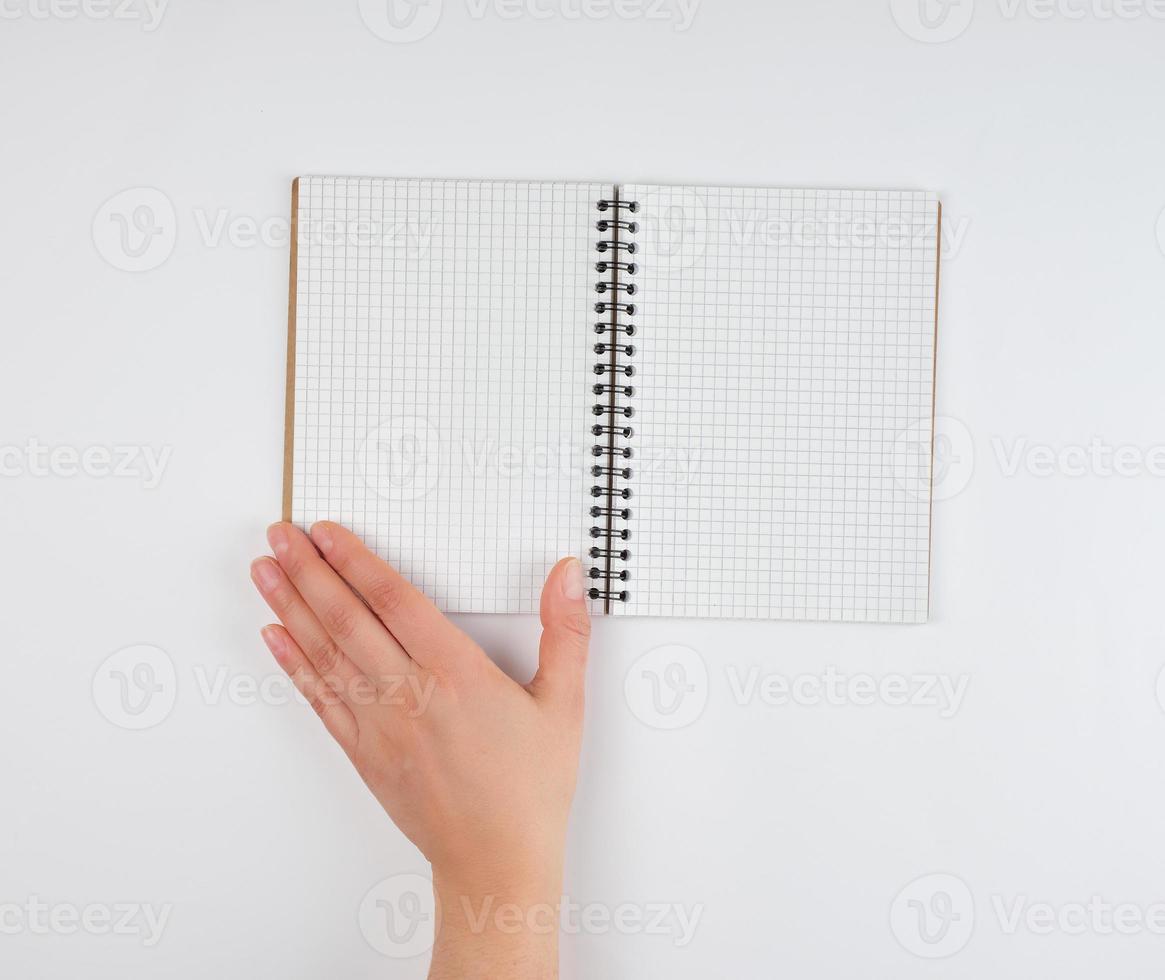 empty open notebook in a cell and a female hand photo