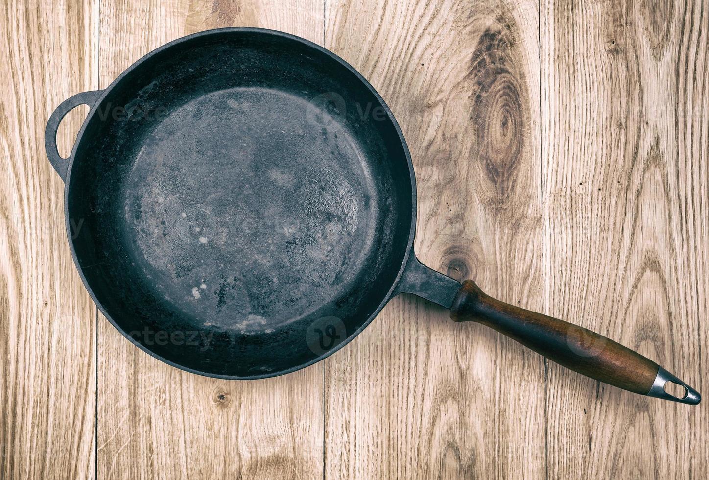 empty black round frying pan with wooden handle photo