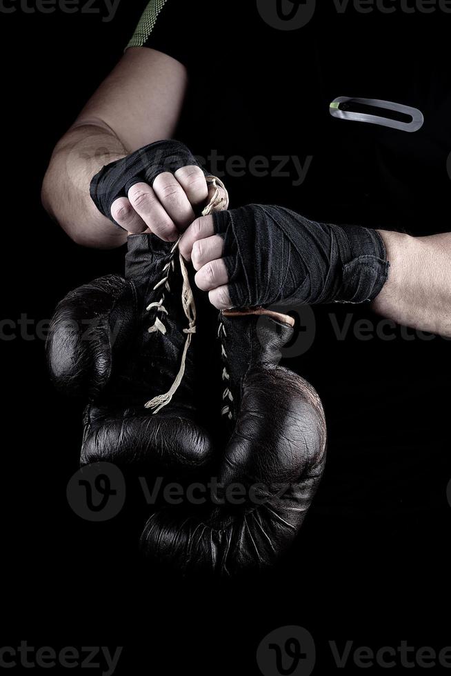 pair of very old boxing sports gloves in men's hands photo