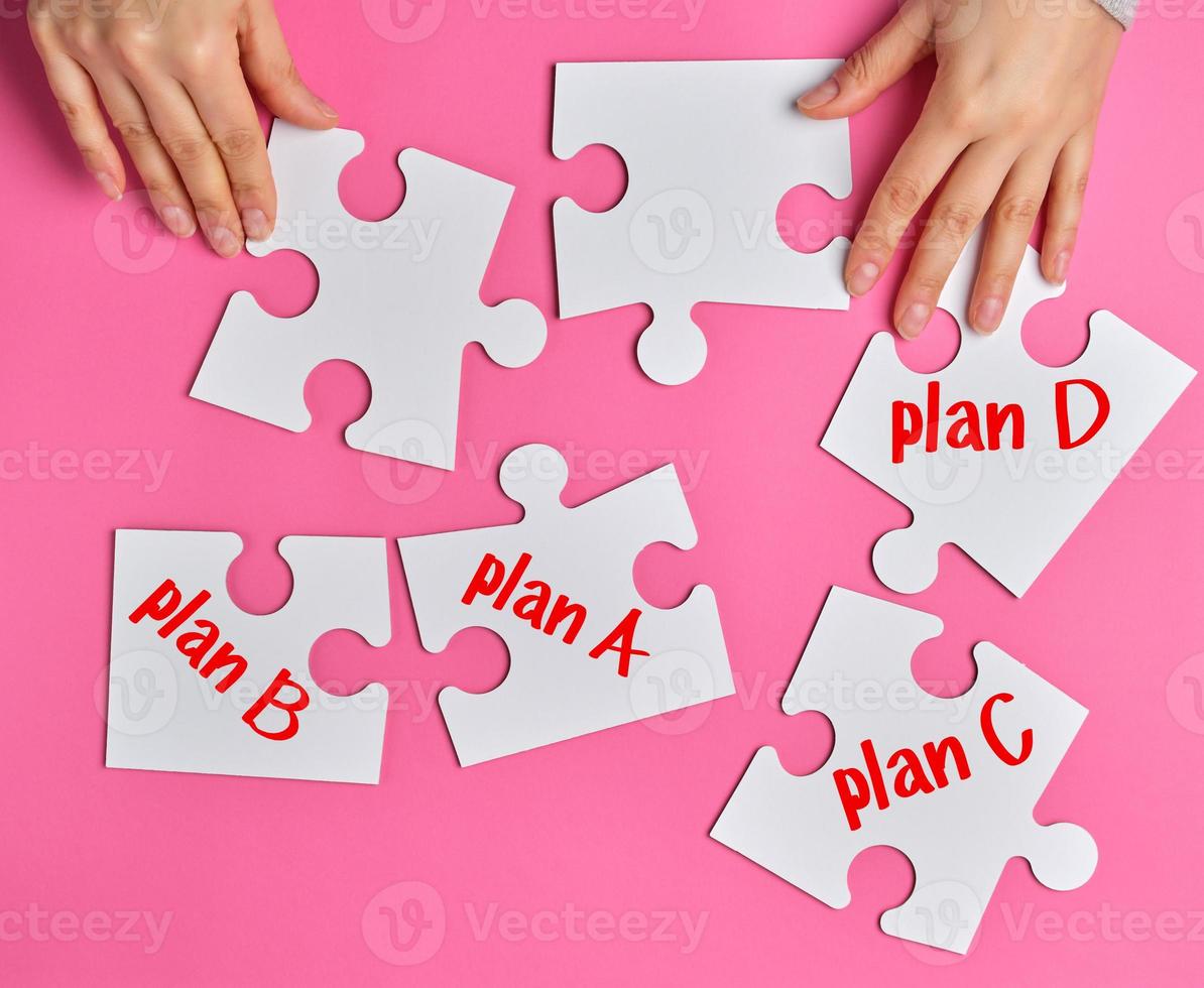 female hands holding empty paper puzzles, near objects with an inscription plan photo