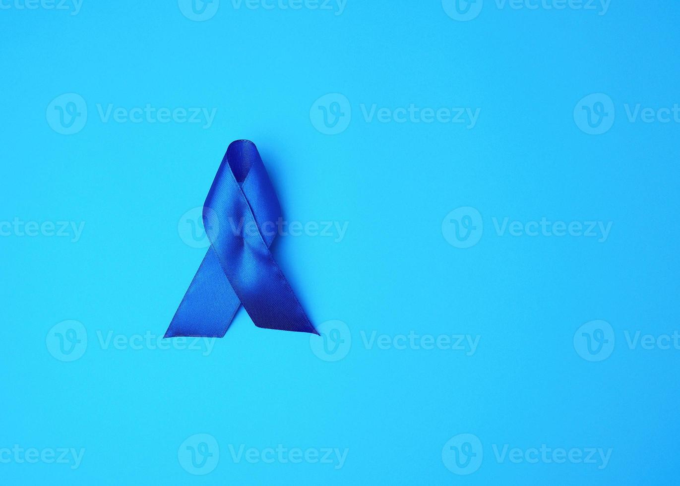 Blue awareness ribbon on blue background photo