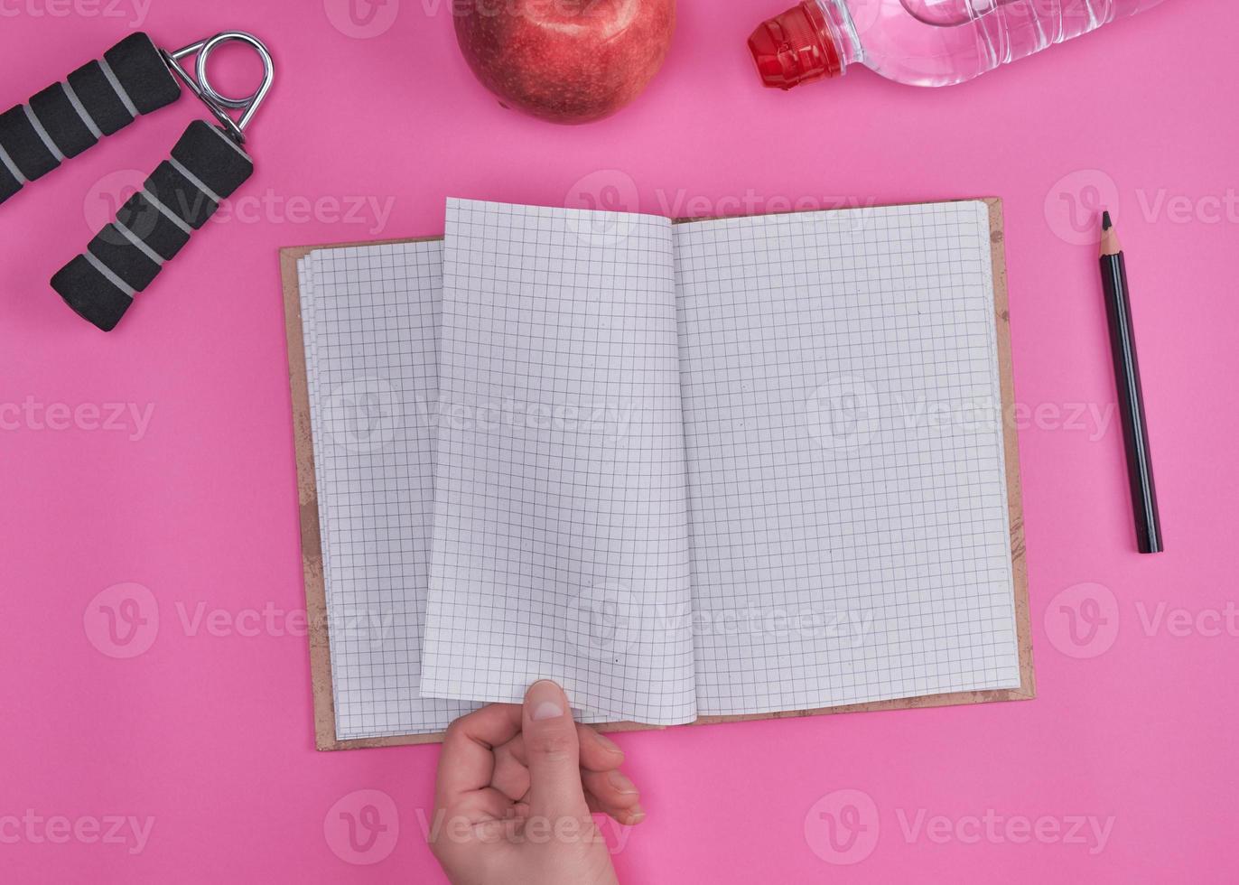 human hand turns over a notebook with empty sheets photo