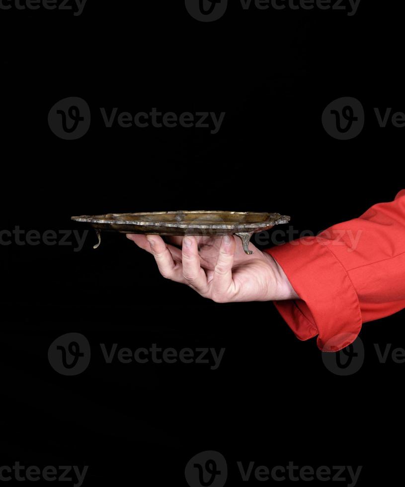 chef's right hand in red uniform holding an empty copper plate photo