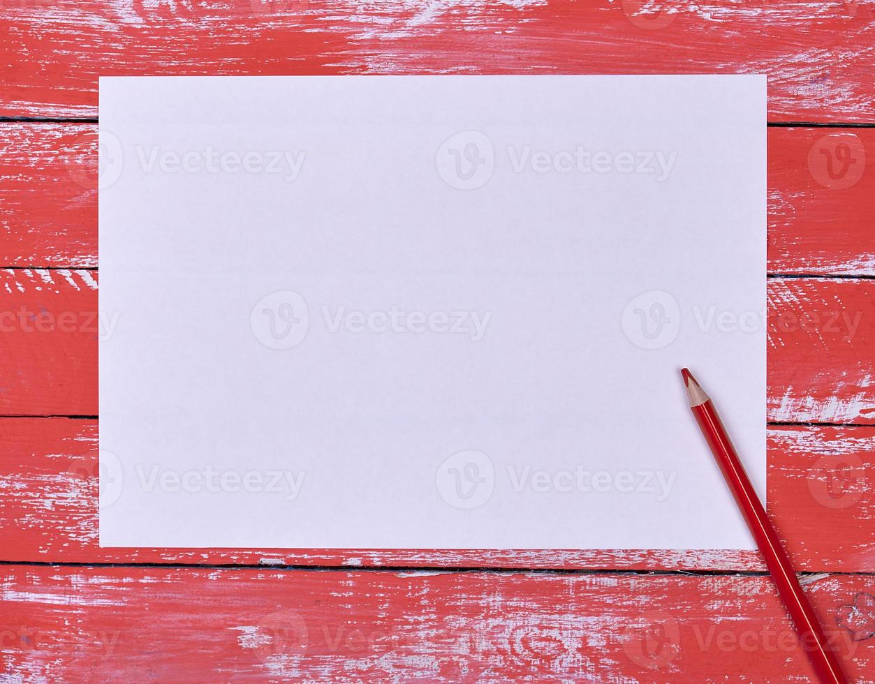 empty white rectangular sheet of paper and red wooden pencil photo