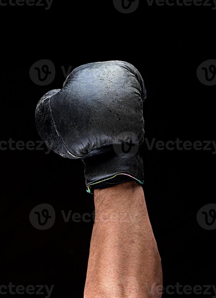 human hand in black leather boxing glove raised up photo