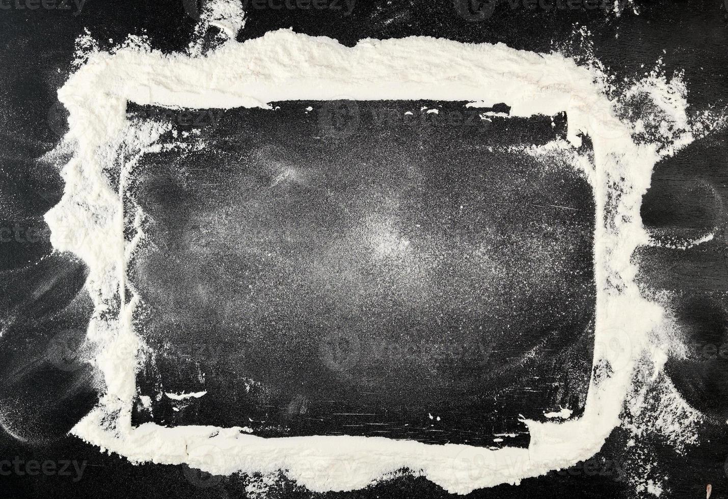 white wheat flour scattered on a black table photo