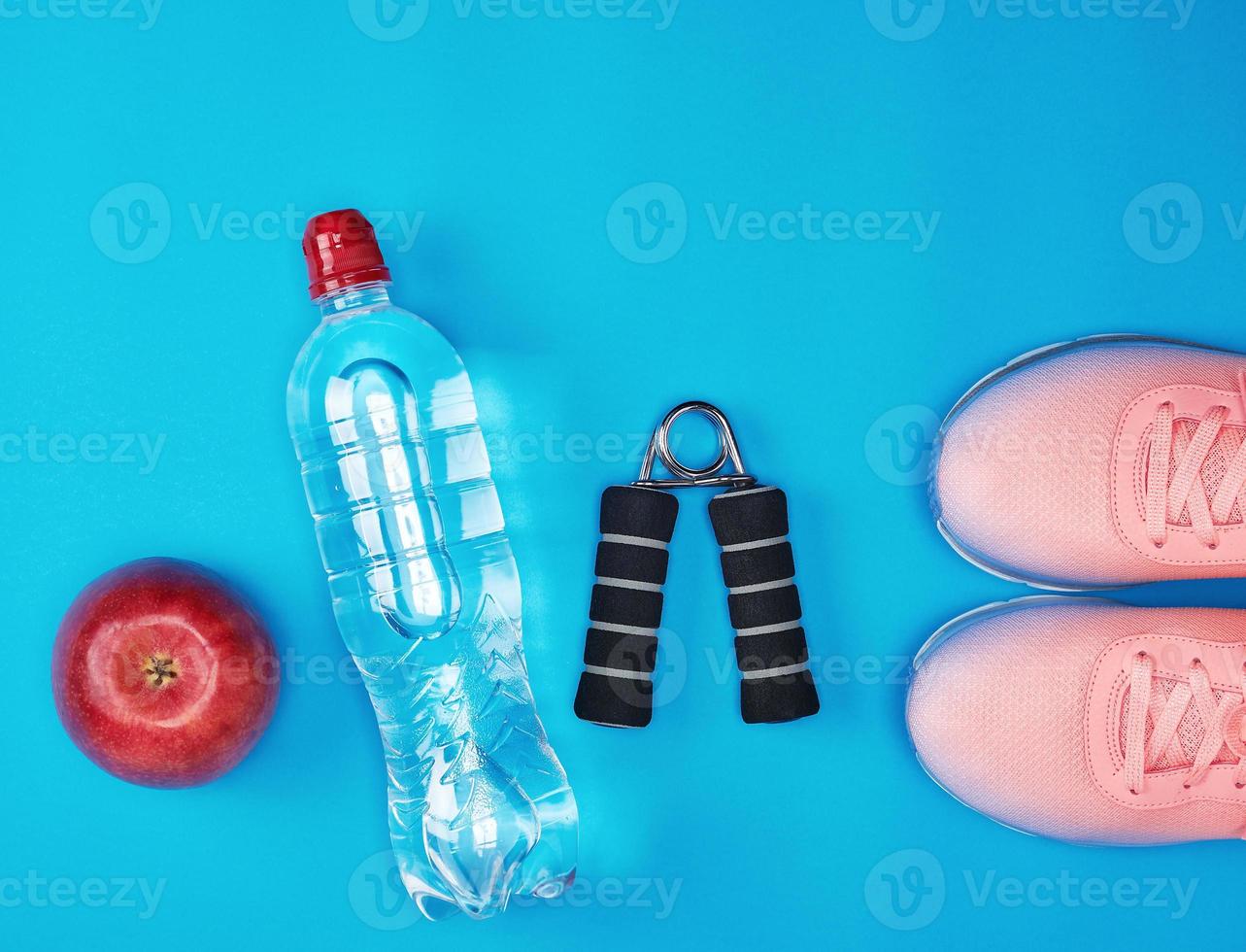 plastic water bottle, red ripe apple and sports expander photo