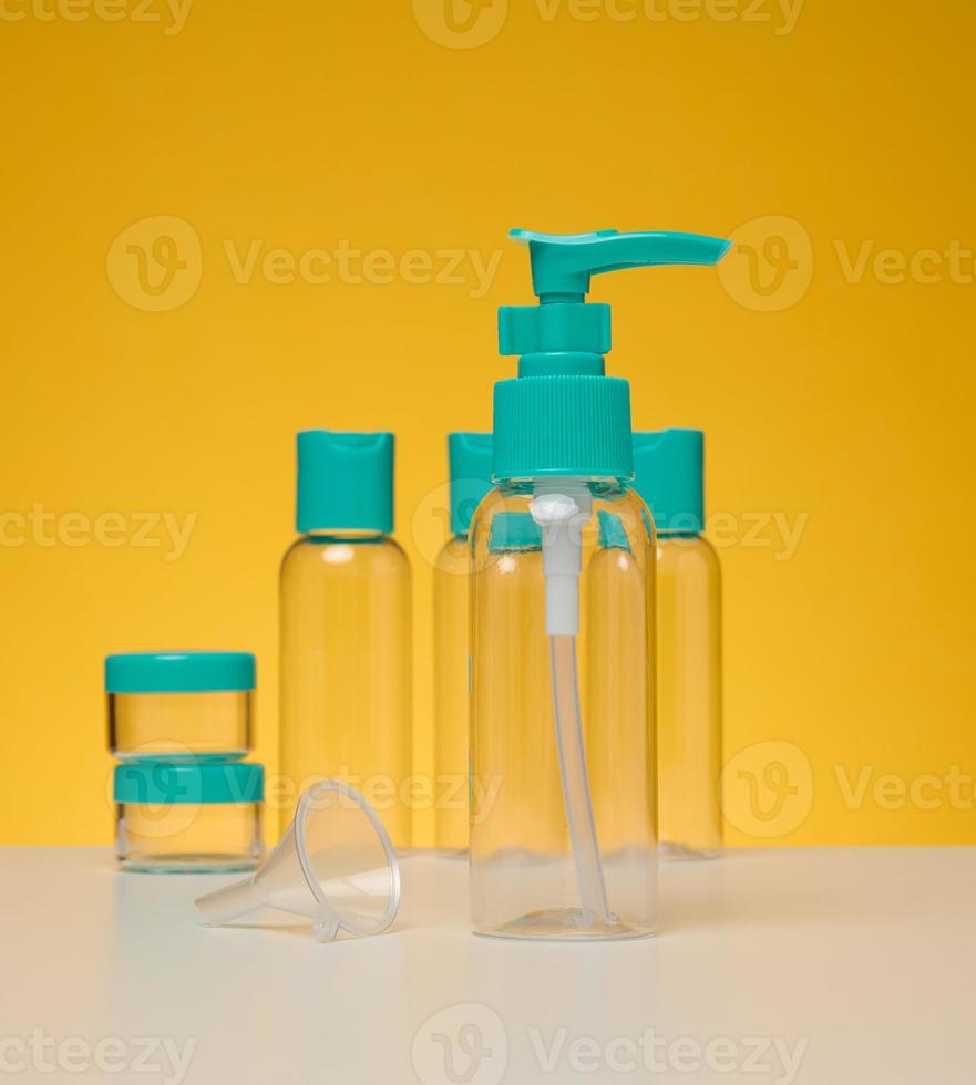botellas de plástico transparentes para cosméticos líquidos sobre un fondo amarillo foto