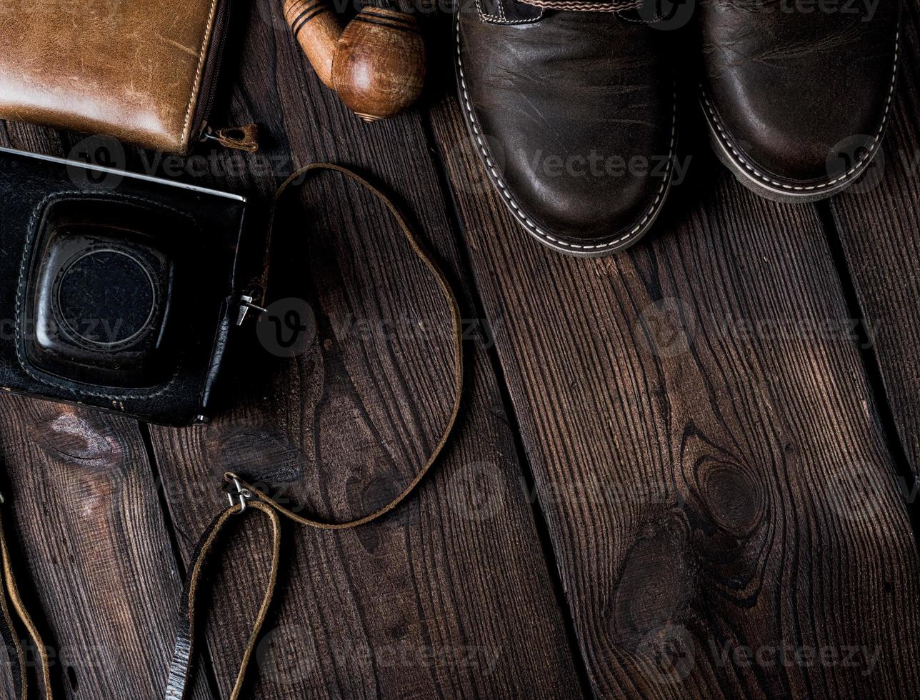 pair of leather brown shoes and an old vintage camera in a case photo