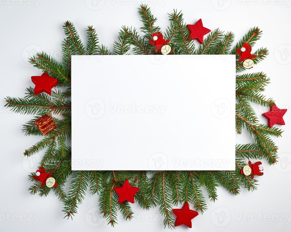 fondo de navidad de felicitación con una hoja blanca vacía y ramas verdes de abeto foto