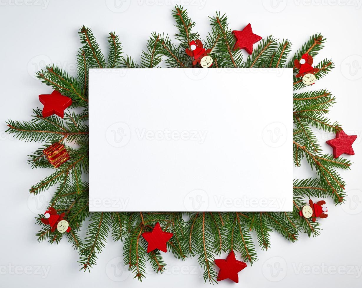 congratulatory Christmas background with an empty white sheet and green branches of spruce photo