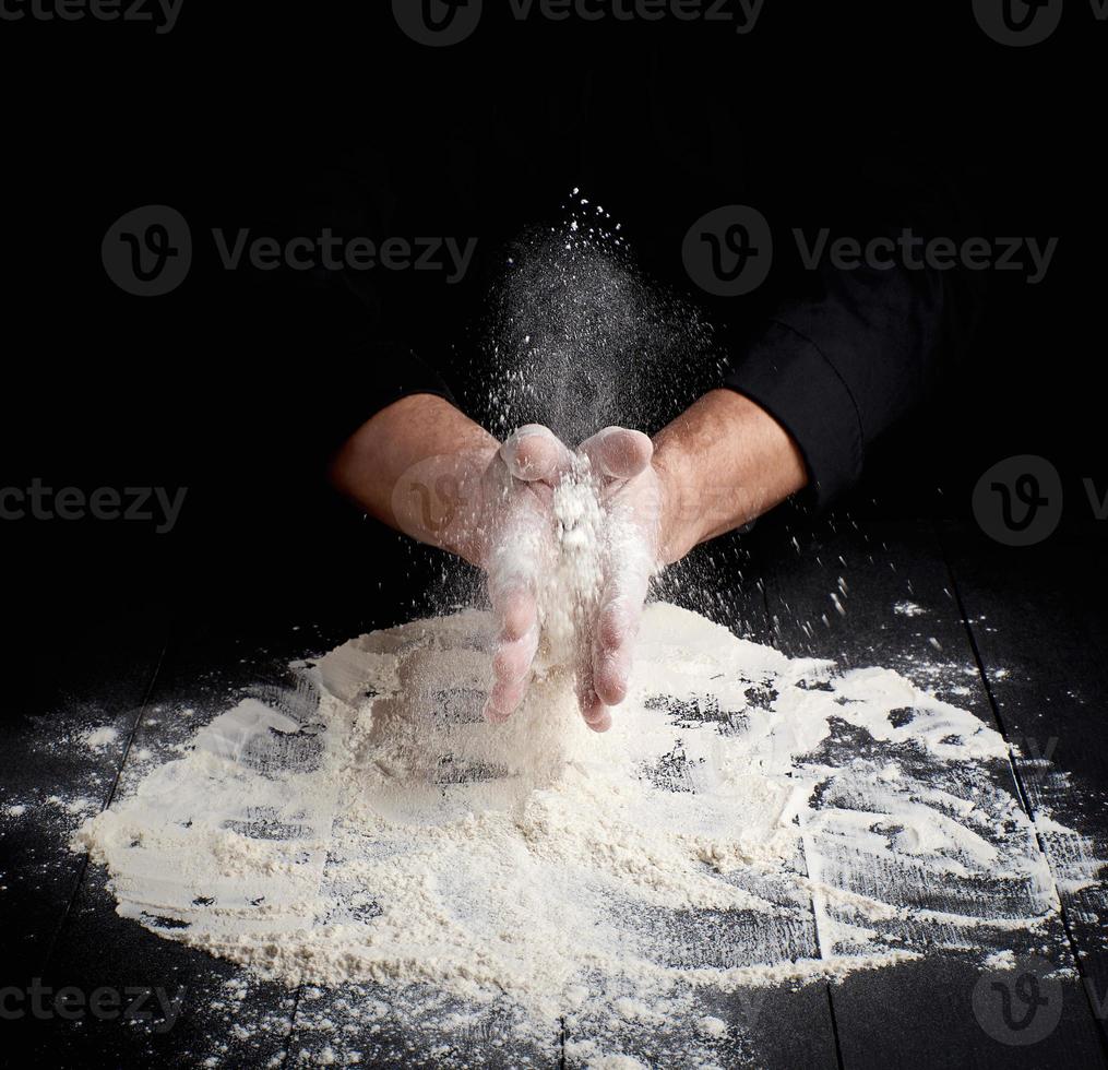 man's hands and splash of white wheat flour photo