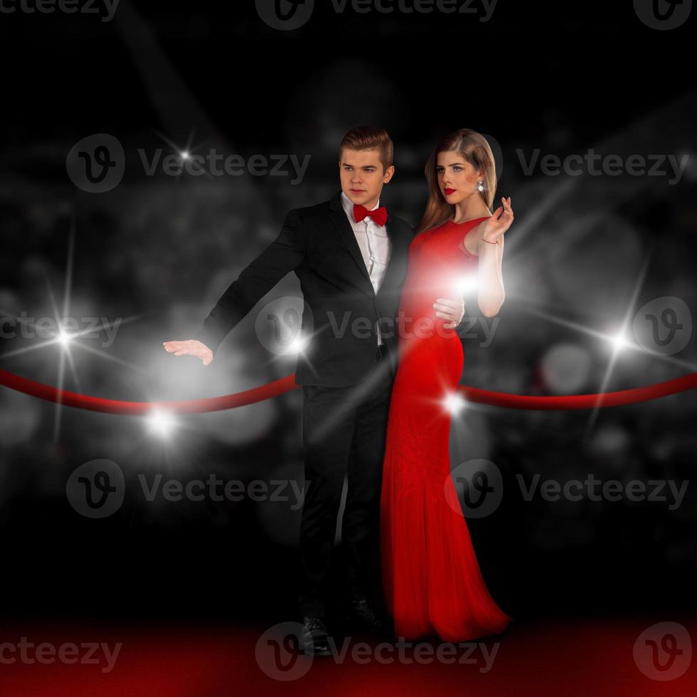 couple on red carpet is posing in paparazzi flashes photo