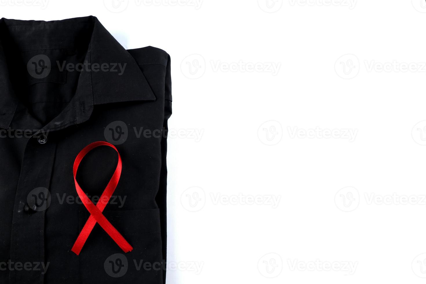 Red ribbon on a black shirt on a white background. Modern treatment and healthcare. AIDS awareness concept. photo