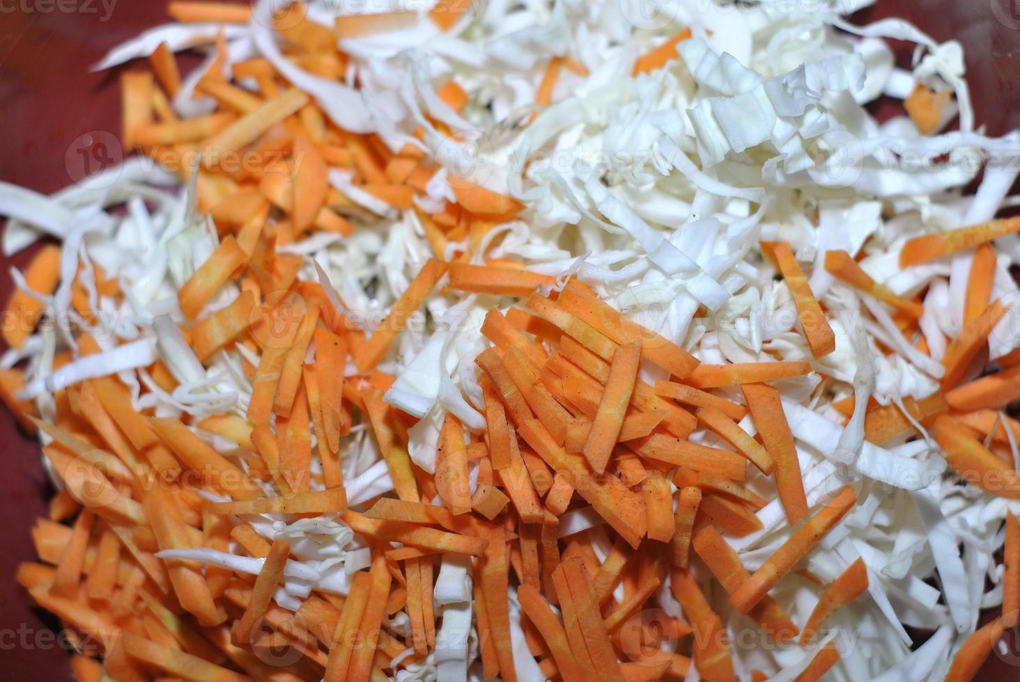 Shredded white cabbage with grated carrots in a basin photo