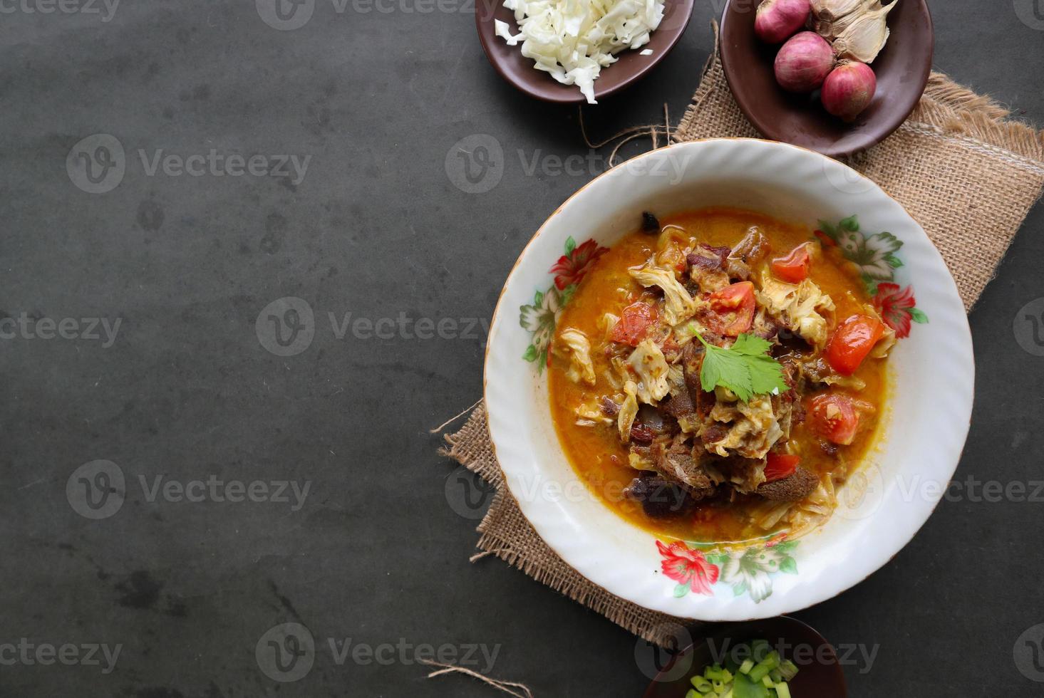 Goat Curry or gulai kambing, food from asia. Delicious goat meat curry served in a bowl.served with tomato, seasoning, celery and cabbage photo