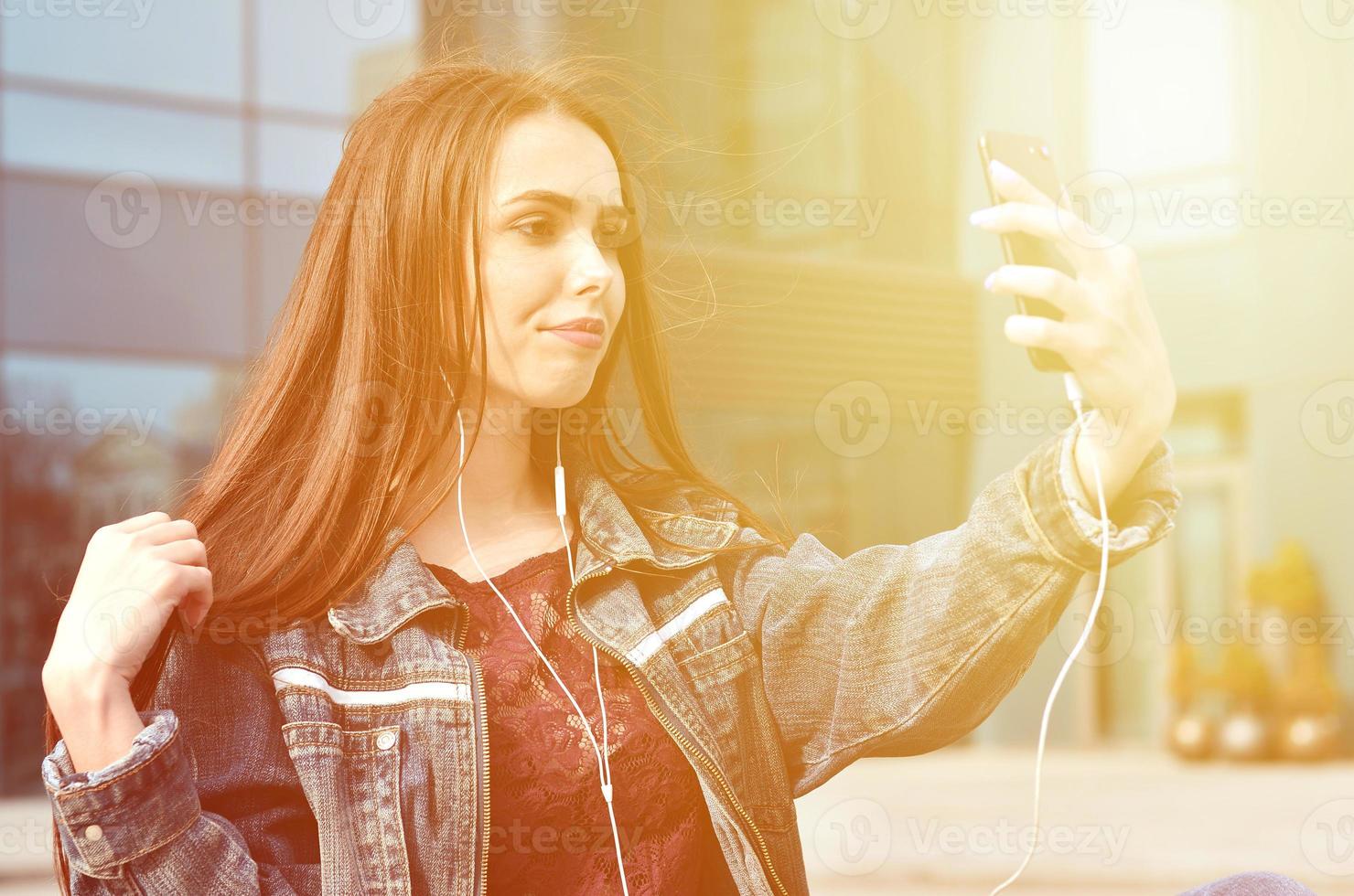 Young girl doing selfie on the background of an office building photo