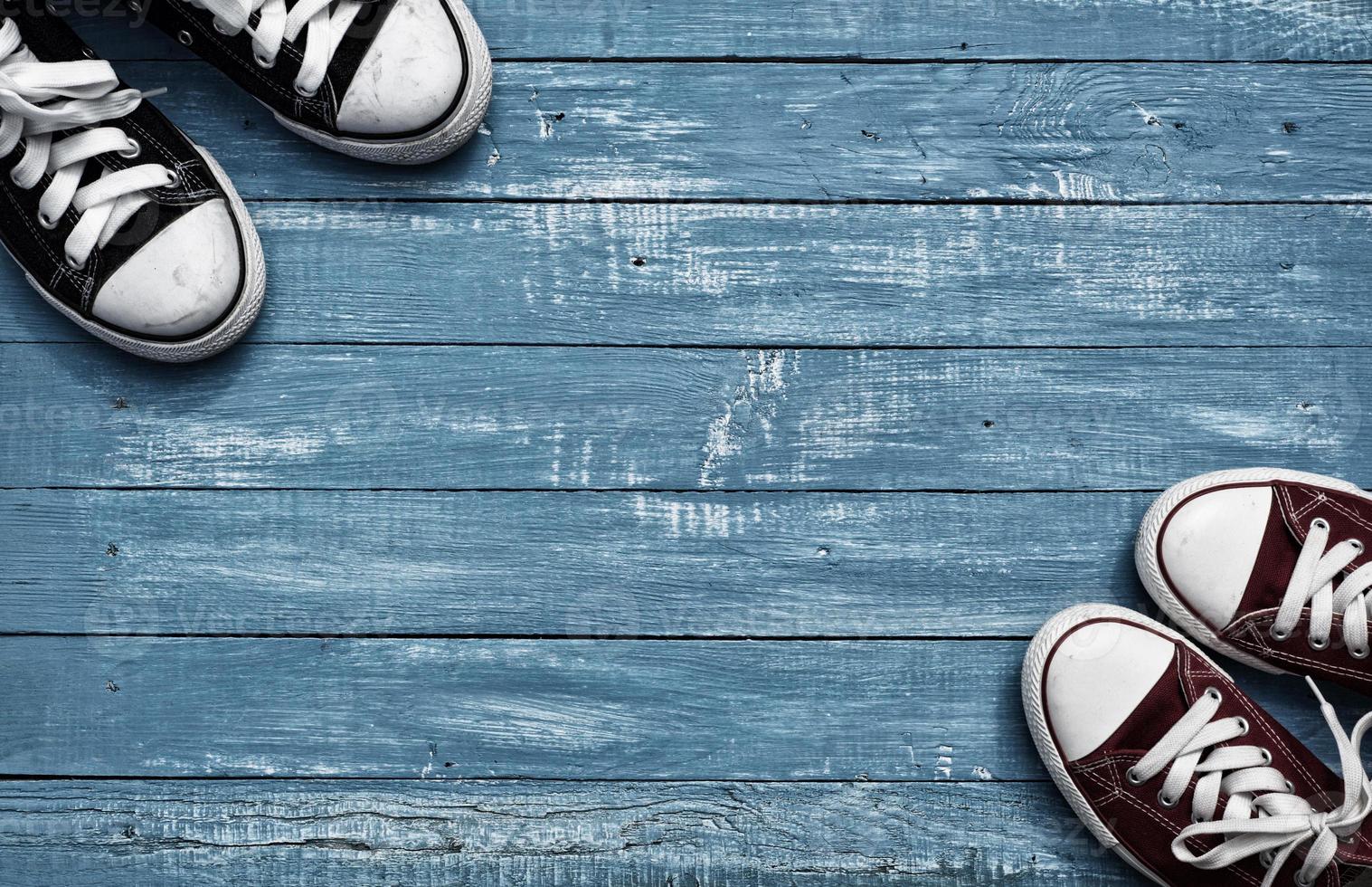 Two pairs of sneakers on vintage blue background photo
