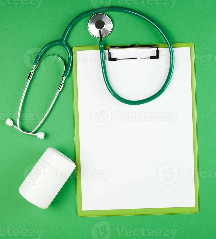 paper holder with empty white sheets, medical stethoscope photo