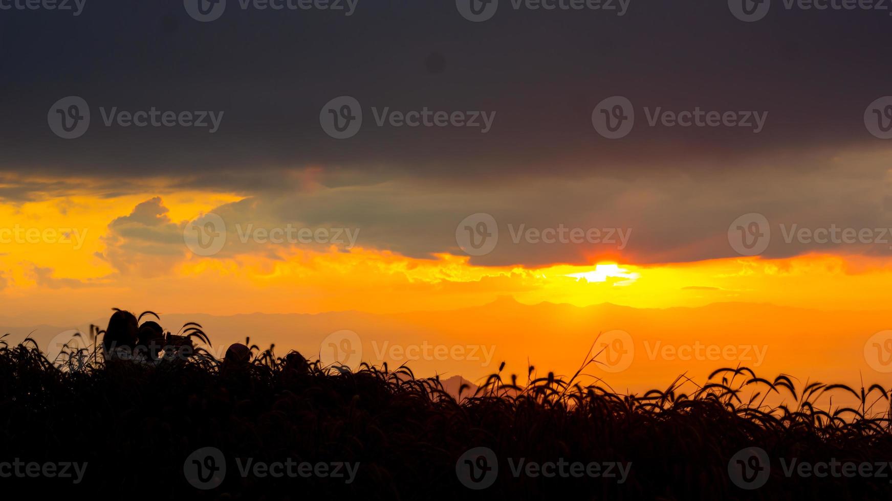 Sunrise in the landscape of hills and meadows. People go up the mountains to see the scenery, the sun, the dawn, and the horizon above the ground photo