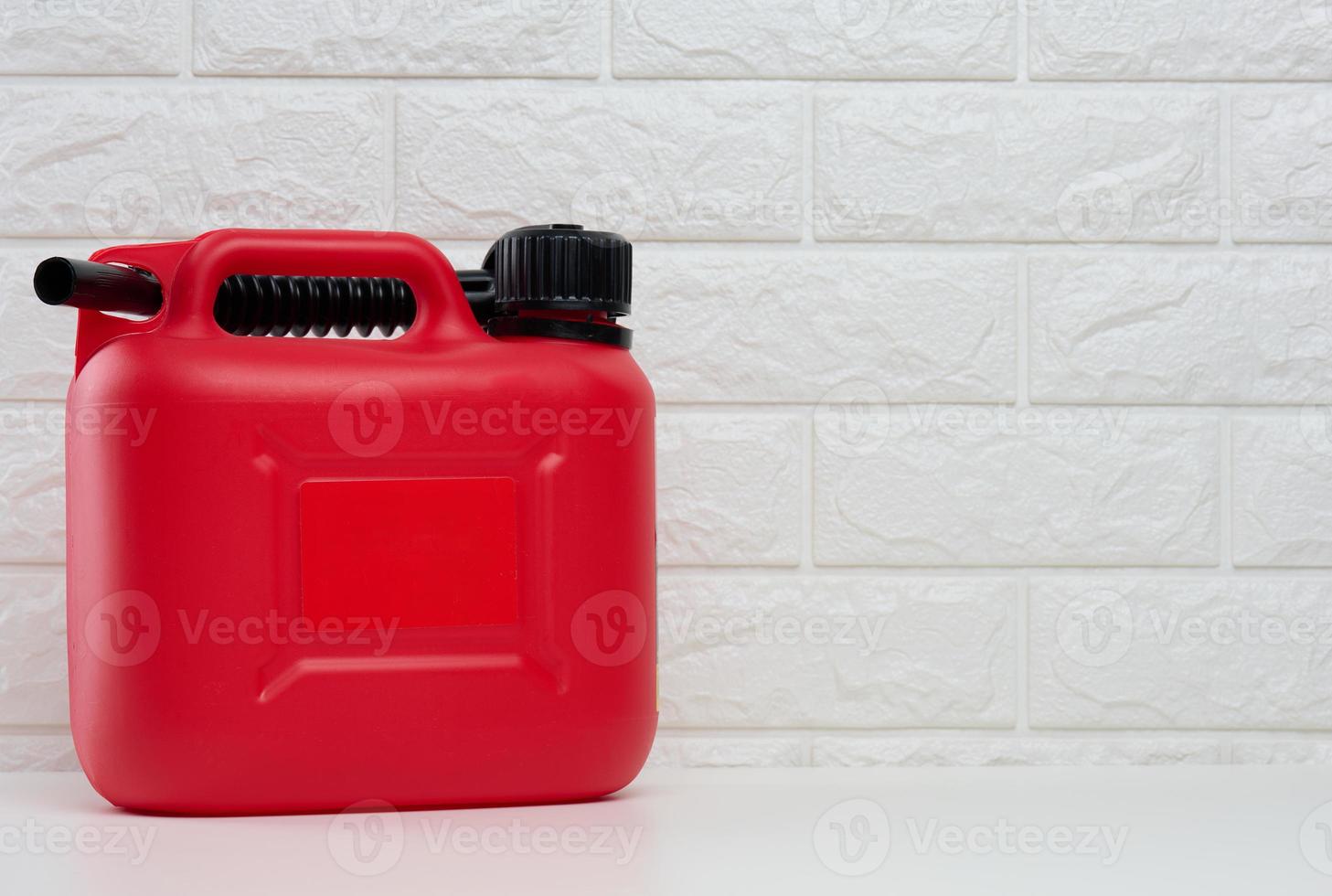 Red plastic canister for liquid fuels and lubricants on a white background photo