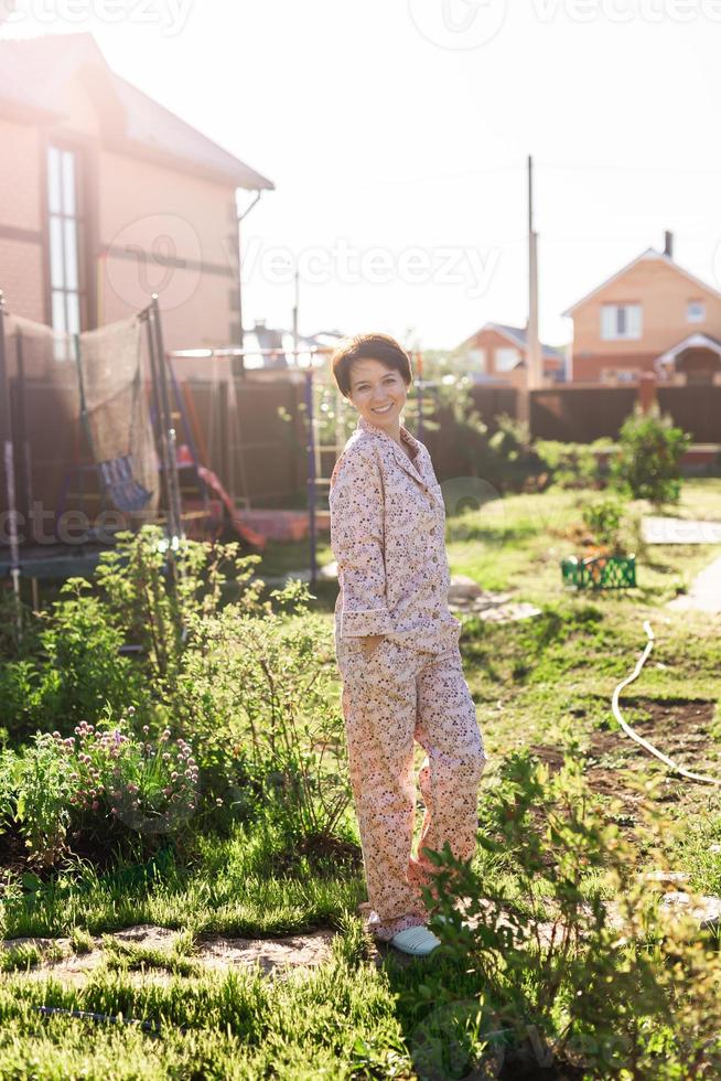 Cheerful woman in home wear pajama summer outdoor backyard in home - sleepwear and homewear concept photo