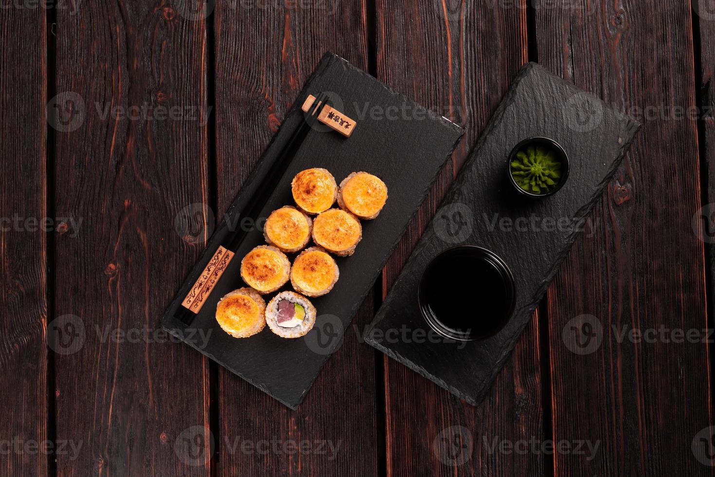 Sushi roll with tuna, avocado and tobiko caviar served on black board top view - Japanese asian food photo