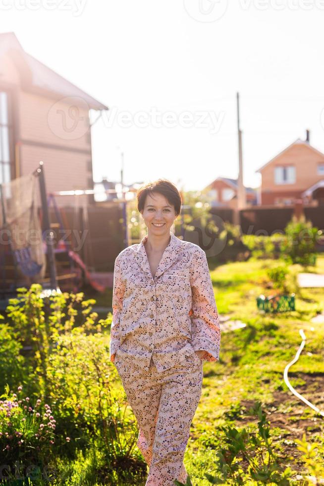 Cheerful woman in home wear pajama summer outdoor backyard in home - sleepwear and homewear concept photo