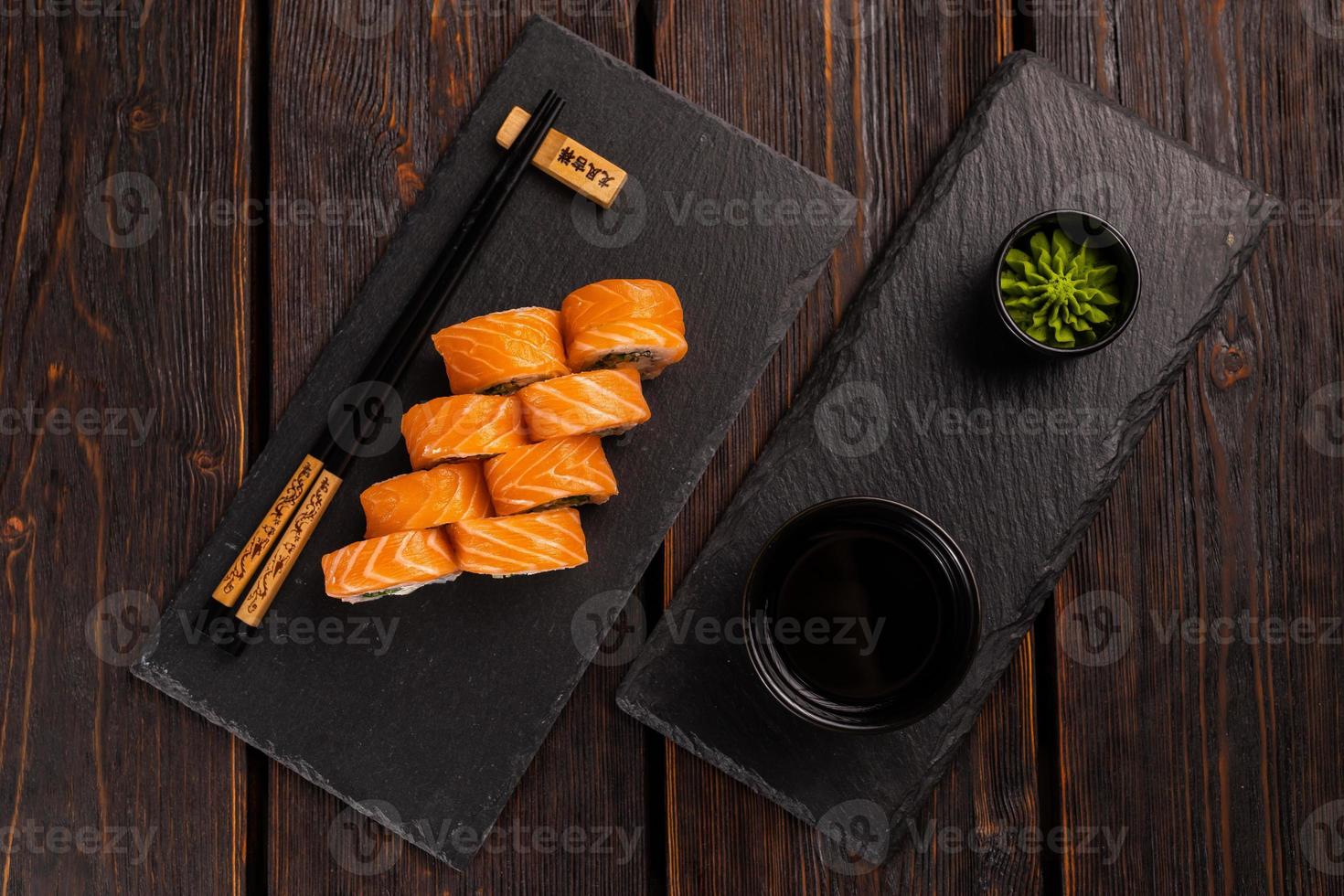 Sushi roll philadelphia with salmon and cucumber and cream cheese on black background. Sushi menu. Japanese food concept top view photo